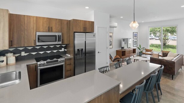 A modern kitchen with wooden cabinets, stainless steel appliances, and a large island. - South Side Modern | Downtown Living | A+ Location., South Side Modern | Downtown Living | A+ Locatio (Chattanooga)