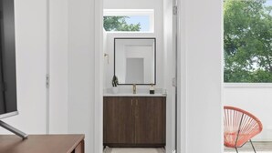 A modern bathroom with a dark wood vanity, a white sink, and a large mirror. - South Side Modern | Downtown Living | A+ Location., South Side Modern | Downtown Living | A+ Locatio (Chattanooga)