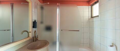 Une salle de bain avec une douche, un lavabo et des toilettes.