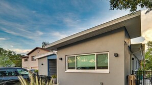 A modern two-story house with a grey exterior, large windows, and a driveway with a parked car. - Pet-Friendly Waterfront Home - 2 Mi to Beach! (Tarpon Springs)