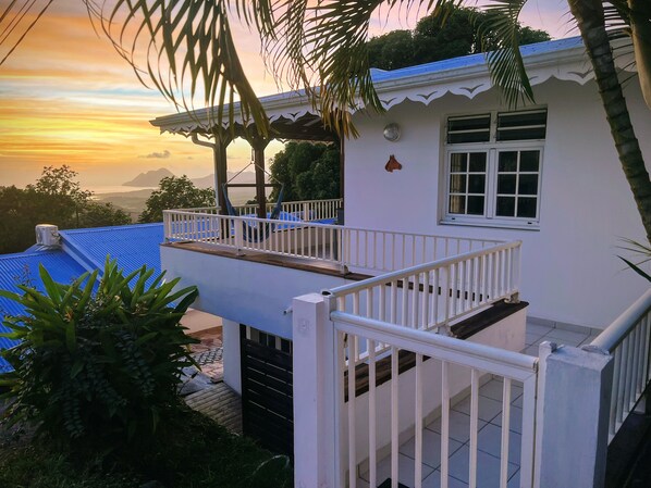 A two-story house with a balcony, a white railing, and a view of the sunset. - Villa Iguana, peaceful duplex, magnificent view of the sea and Diamond Rock, swimming pool (Sainte-Luce)