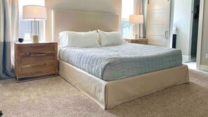 A bedroom with a bed, bedside tables, an air conditioning unit, and a sliding door. - Riverstone Village Pet Friendly Beach Cruisers Sleeps 6 (Coeur d'Alene)