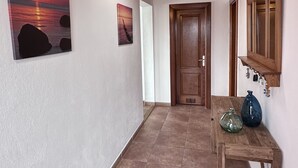 A hallway with wooden ceiling beams, a door, and two wall-mounted light fixtures. - Luxury villa - with a heated pool, hot tub, sea views, aircon, WiFi, UK TV (Playa Blanca)