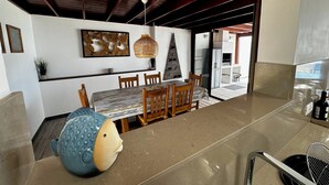 A dining area with a wooden table, chairs, and a decorative fish sculpture. - Luxury villa - with a heated pool, hot tub, sea views, aircon, WiFi, UK TV (Playa Blanca)