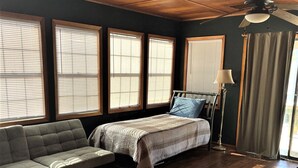 Une pièce avec un lit, un canapé et un ventilateur de plafond.