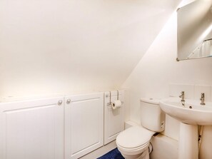 A small, white bathroom with a toilet, a sink, and a cabinet. - Cosy Country Lodge - UK40802 (High Halden, near Tenterden)