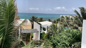 A resort with a pool, palm trees, and a view of the ocean. - Gorgeous cozy apartment with pool, balcony and roof top in Punta Sur! Casa Ama 4 (Isla Mujeres)