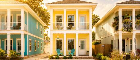 A row of two-story houses with balconies, a front porch, and a mailbox.
