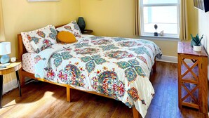 A bedroom with a bed, bedside table, lamp, and a window with a view. - Casa del Sole • Downtown • 3 Ensuites • Pets OK (Pensacola)