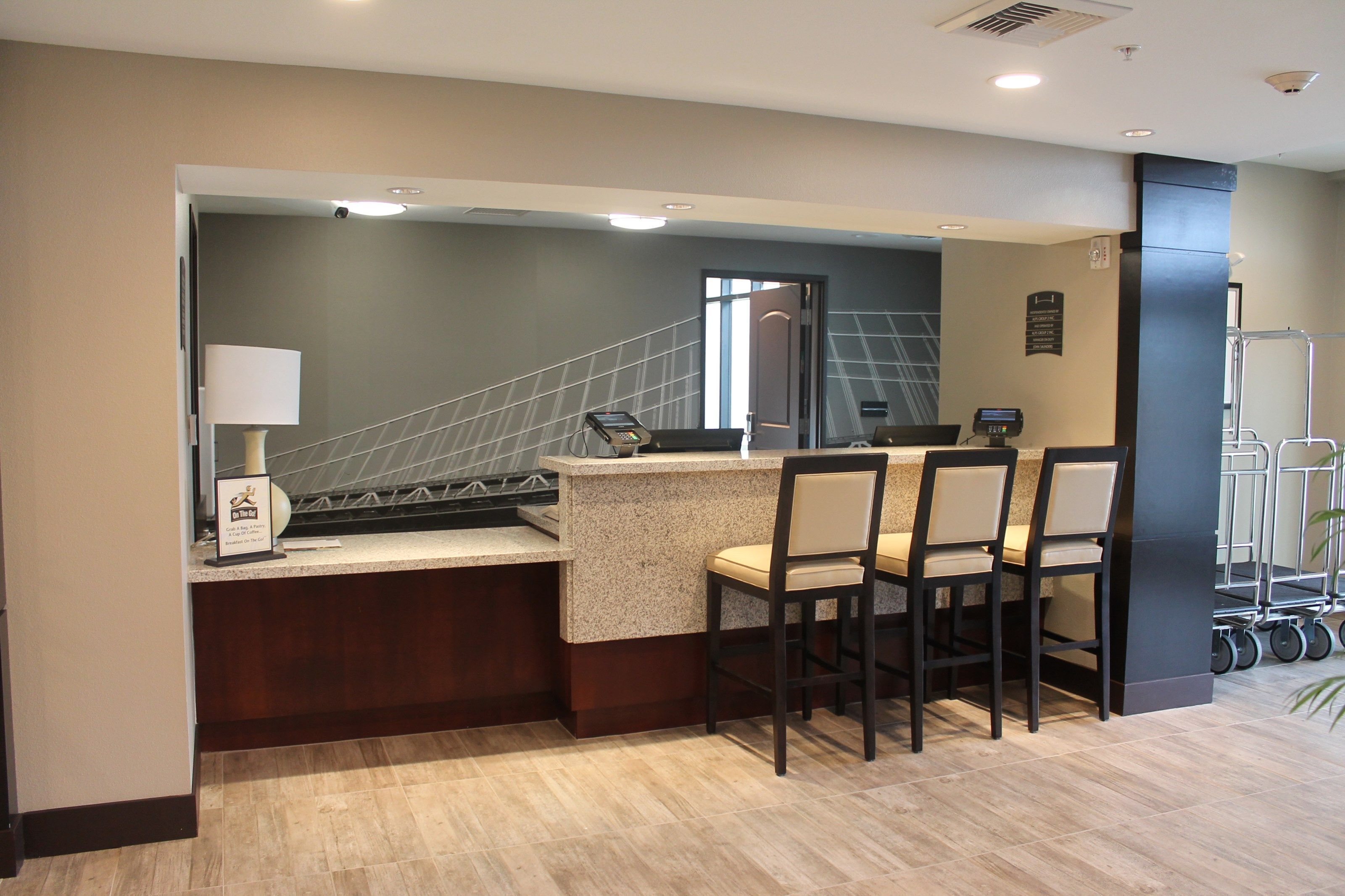A modern kitchen area with a bar counter, seating, and a staircase leading to an upper level.