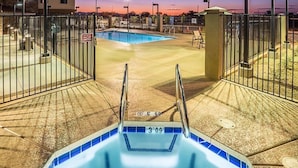 A swimming pool area with a hot tub, surrounded by a fence and a gate. - 2 Bedroom | Heated Outdoor Pool + Hot Tub (Chandler)