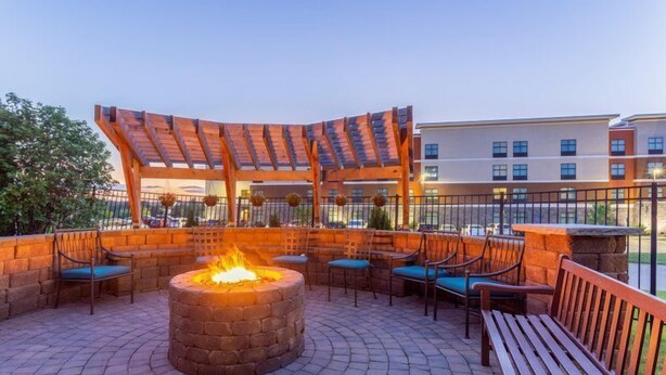 An outdoor patio with a fire pit, seating, and a pergola structure. - Studio | Free Breakfast, Indoor Pool & Hot Tub (Davenport)