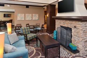 Eine Hotlellobby mit Kamin, Sitzgelegenheiten und Kunstwerken an den Wänden.