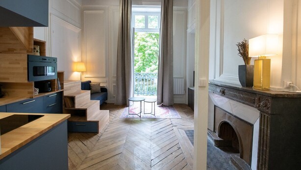 A modern kitchen with a built-in oven, a dining area with a table and chairs, and a fireplace. - Le Chavannes-Ecrin élégant & Cosy- Pentes X Rousse (Lyon)