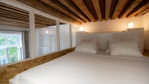 A bedroom with a wooden ceiling, a large bed with white bedding, and a window with curtains. - Le Chavannes-Ecrin élégant & Cosy- Pentes X Rousse (Lyon)