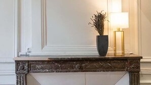 A fireplace with a dark mantel and a vase of dried flowers. - Le Chavannes-Ecrin élégant & Cosy- Pentes X Rousse (Lyon)