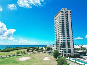 Ein Hochhaus-Hotel mit Pool und Golfplatz im Vordergrund.