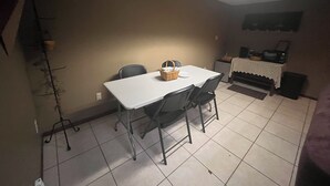 A dining area with a table and chairs, a microwave, and a small refrigerator. - Cozy 2 bedroom suite with private entrance and continental breakfast. (Port Matilda)