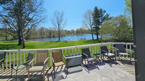 A deck with outdoor furniture overlooking a lake. - Big Red Lakefront Getaway & Golf Retreat at Canadian Lakes (Stanwood)