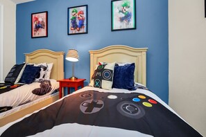 A bedroom with a bed, a nightstand, and three framed artworks on the wall.