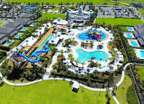 Eine Vogelperspektive eines Resorts mit mehreren Swimmingpools, einem Wasserpark und verschiedenen Hotelgebäuden.