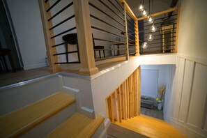 Staircase leads to a cozy landing area with a bench and a potted plant.