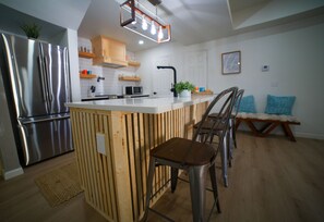 Enjoy cooking in this well-equipped kitchen with a central island, stainless steel appliances, and ample storage.