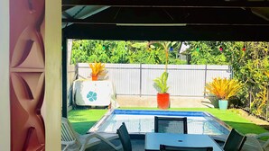 A covered outdoor area with a pool table, chairs, and potted plants. - Cheerful Bungalow with pool! (Apia)