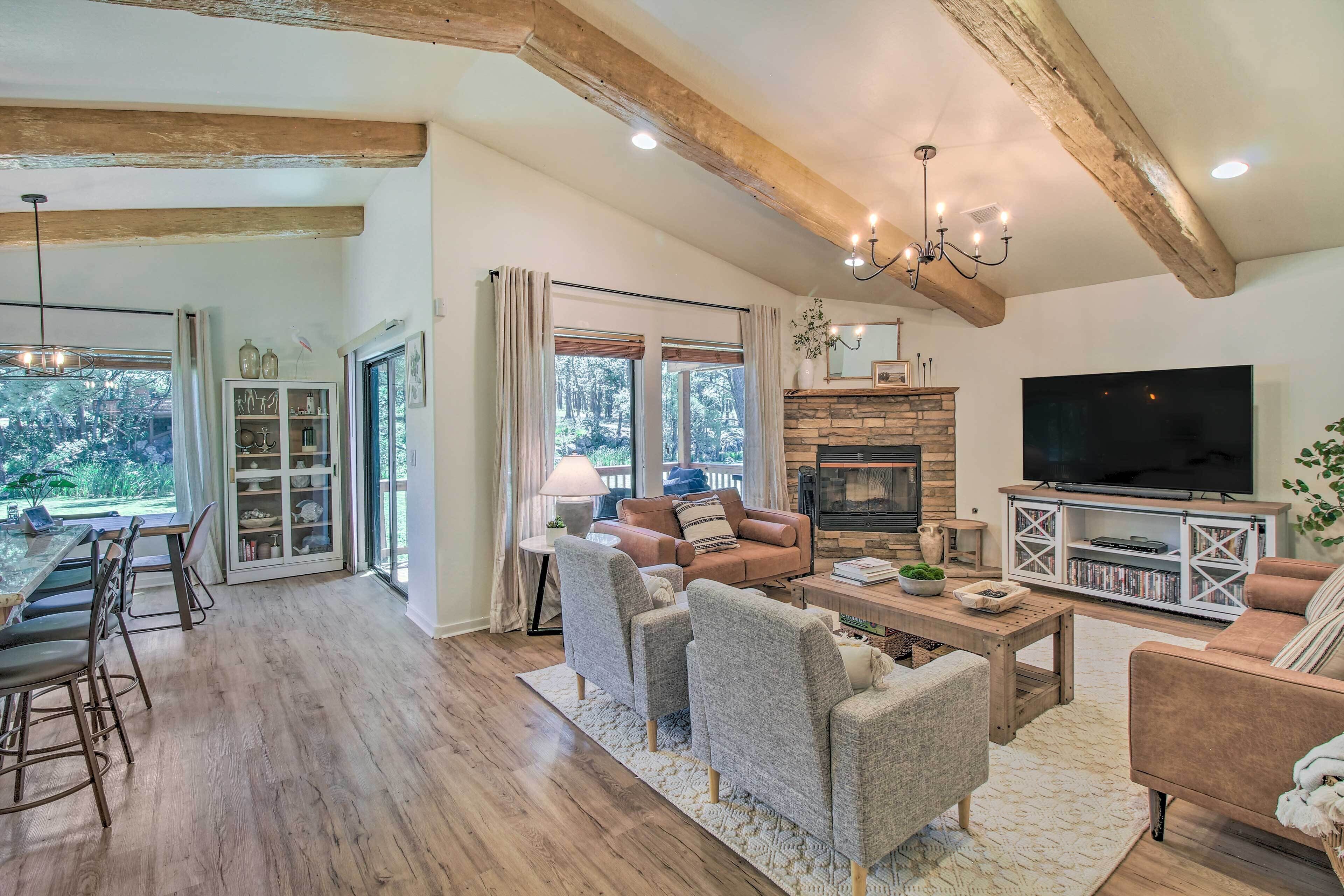 A spacious living room with a fireplace, a television, and a dining area with a table and chairs.