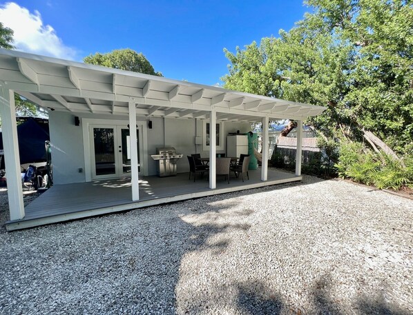 A covered patio with a grill, seating area, and a refrigerator. - New 2/1 Remodeled Cozy Home in Tavernier Key (Tavernier)