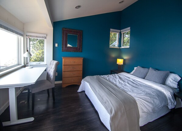 A bedroom with a bed, a desk, a chair, a dresser, and two windows. - Serene Lakefront Escape: Private Beach & Kayaks (Redmond)