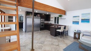 A modern kitchen with a central island, stainless steel appliances, and a wooden ceiling. - Lakefront & private beach  (Redmond)