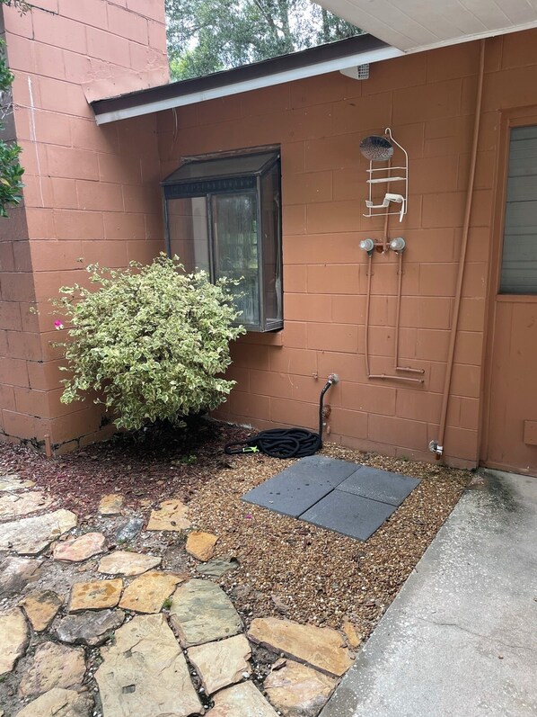 A brick exterior with a window, a door, and a hose on the ground. - Canal front pool home to Dora Chain of Lakes (Tavares)