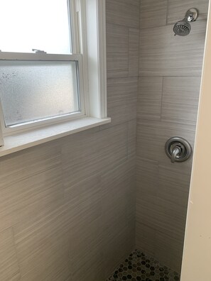 Een douche, handdoeken, zeep, toiletpapier