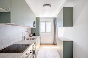 A modern kitchen with a built-in oven, a sink, and a coffee maker.