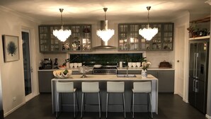 A modern kitchen with a central island, bar stools, and a refrigerator. - Views from Stradbroke to Tweed Heads (Wongawallan)