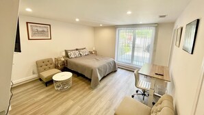Ein Schlafzimmer mit Bett, Schreibtisch, Stuhl und einer Couch.