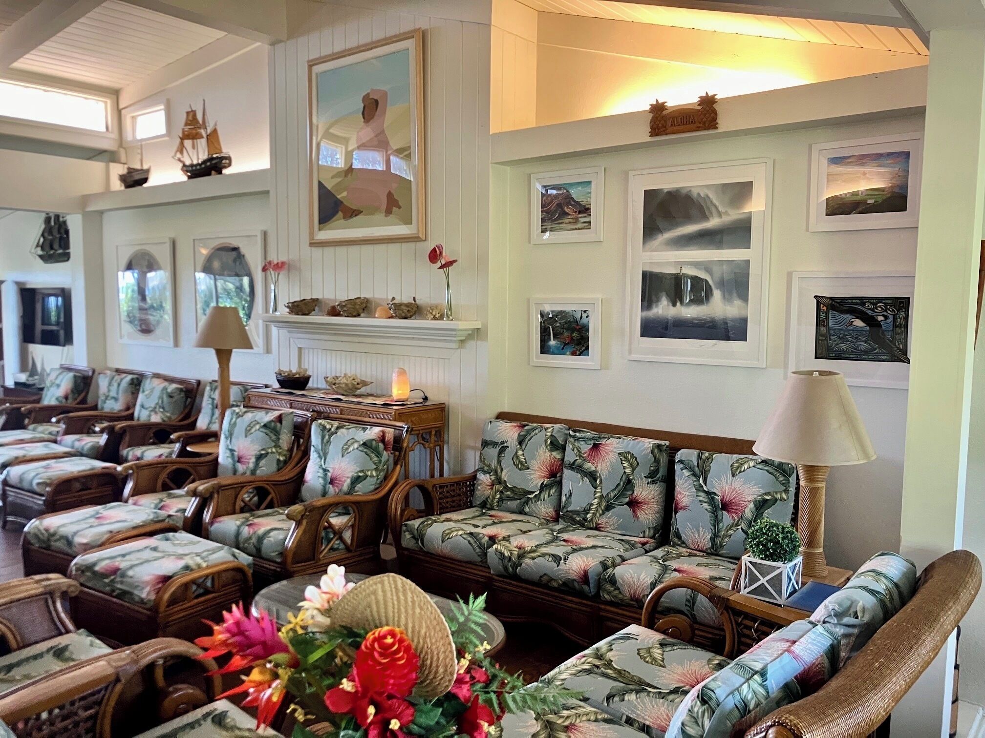 A spacious lounge area with multiple seating options, including sofas and chairs, arranged around a central fireplace.