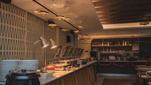 A modern bar area with a buffet setup, including a coffee station and a variety of food items. - Citadines Connect City Centre Singapore (Singapore)