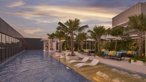A modern pool area with lounge chairs and palm trees, surrounded by buildings with large windows and a clear sky. - Citadines Connect City Centre Singapore (Singapore)