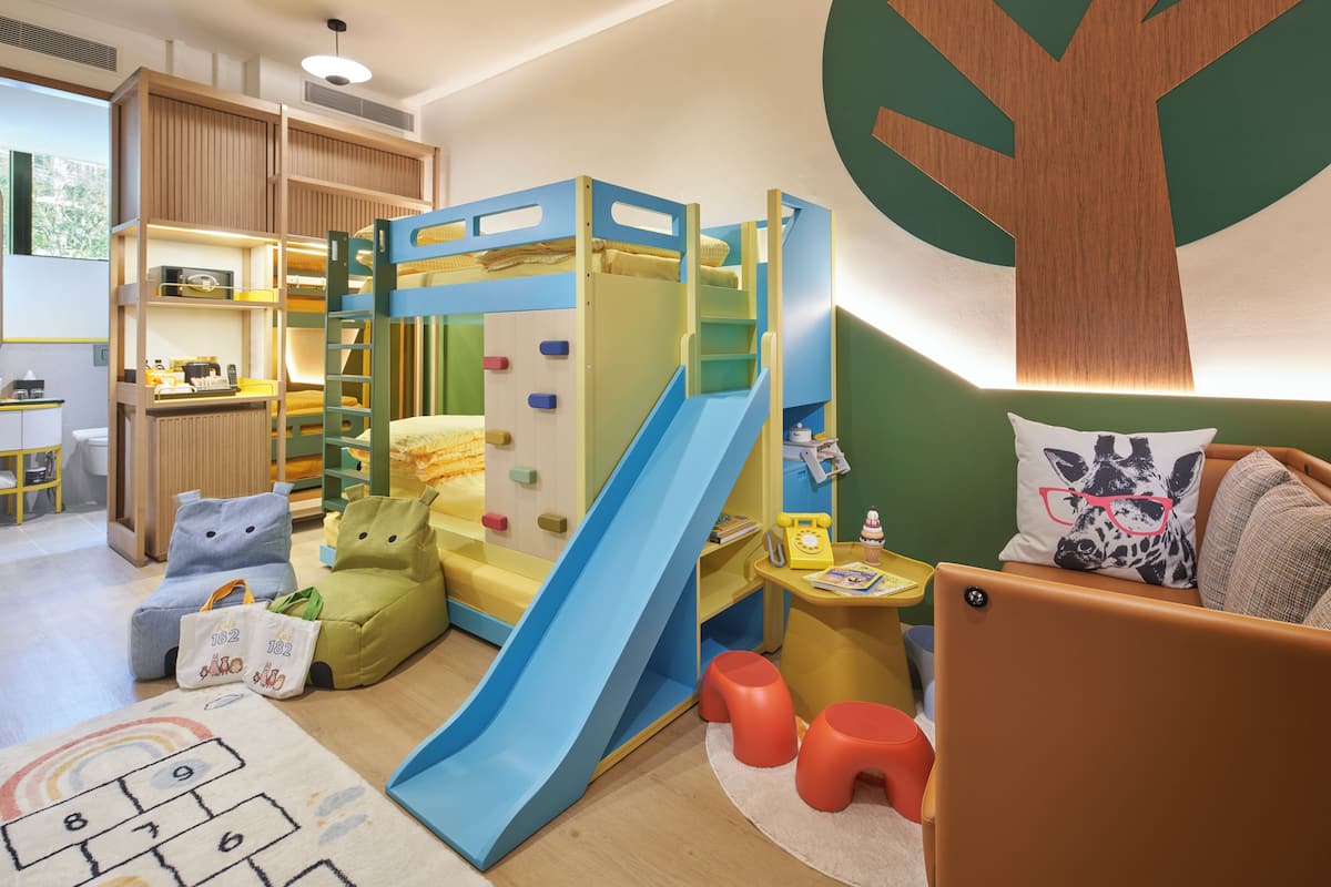 Ein Kinderzimmer mit Etagenbetten, einer Rutsche und einem Spielbereich.