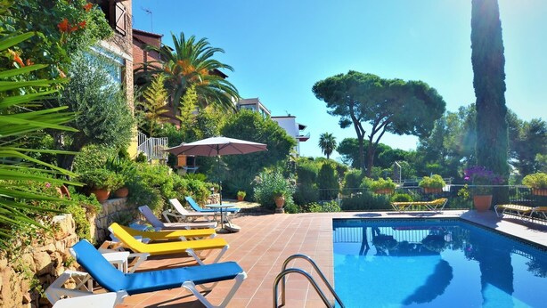 A poolside area with lounge chairs and a pool.