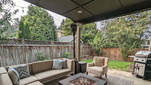 An outdoor patio with a sofa, armchair, and a fire pit. - Spacious 3-bedroom home with outdoor space (Eugene)