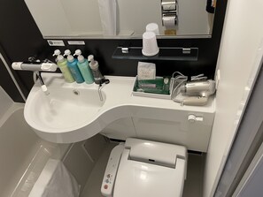 A bathroom with a white sink, a mirror, a towel rack, and a toilet.