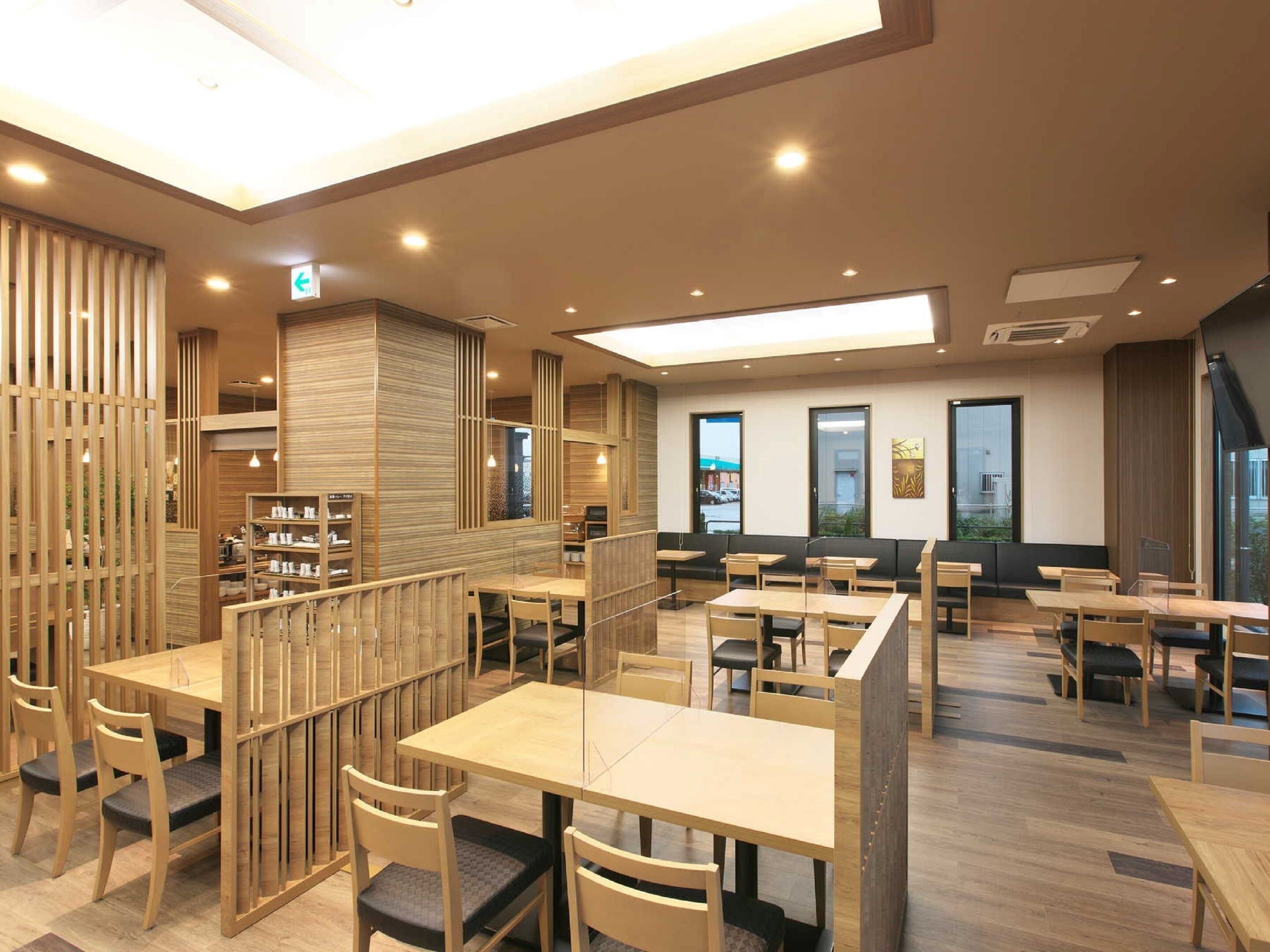 A modern restaurant with wooden furniture and a high ceiling.