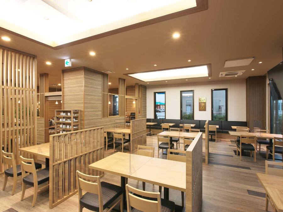 A modern restaurant with wooden furniture and a high ceiling.