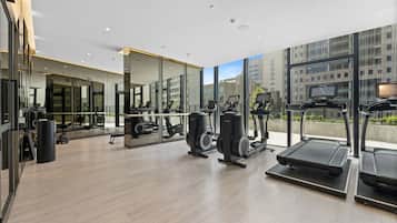 A modern gym with treadmills, exercise bikes, and weight machines.