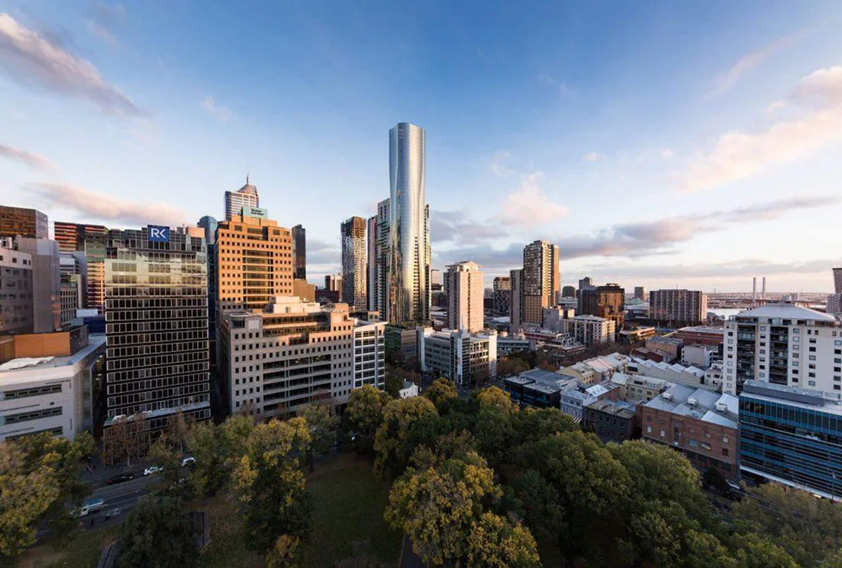 A cityscape with a variety of high-rise buildings, including a prominent skyscraper with a reflective glass facade.