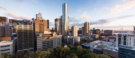 A cityscape with a variety of high-rise buildings, including a prominent skyscraper with a reflective glass facade.