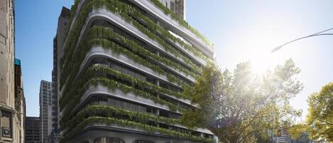 A modern building with curved architecture and green terraces.